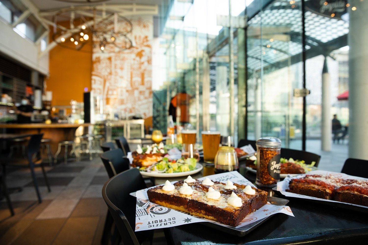 Event guests dining at long tables inside Joyride Pizza at Yerba Buena Gardens
