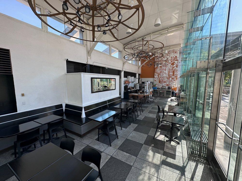 Interior dining room of Joyride Pizza with two-story glass windows